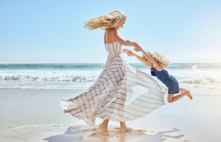 A mother and her young daughter playing together on the beach